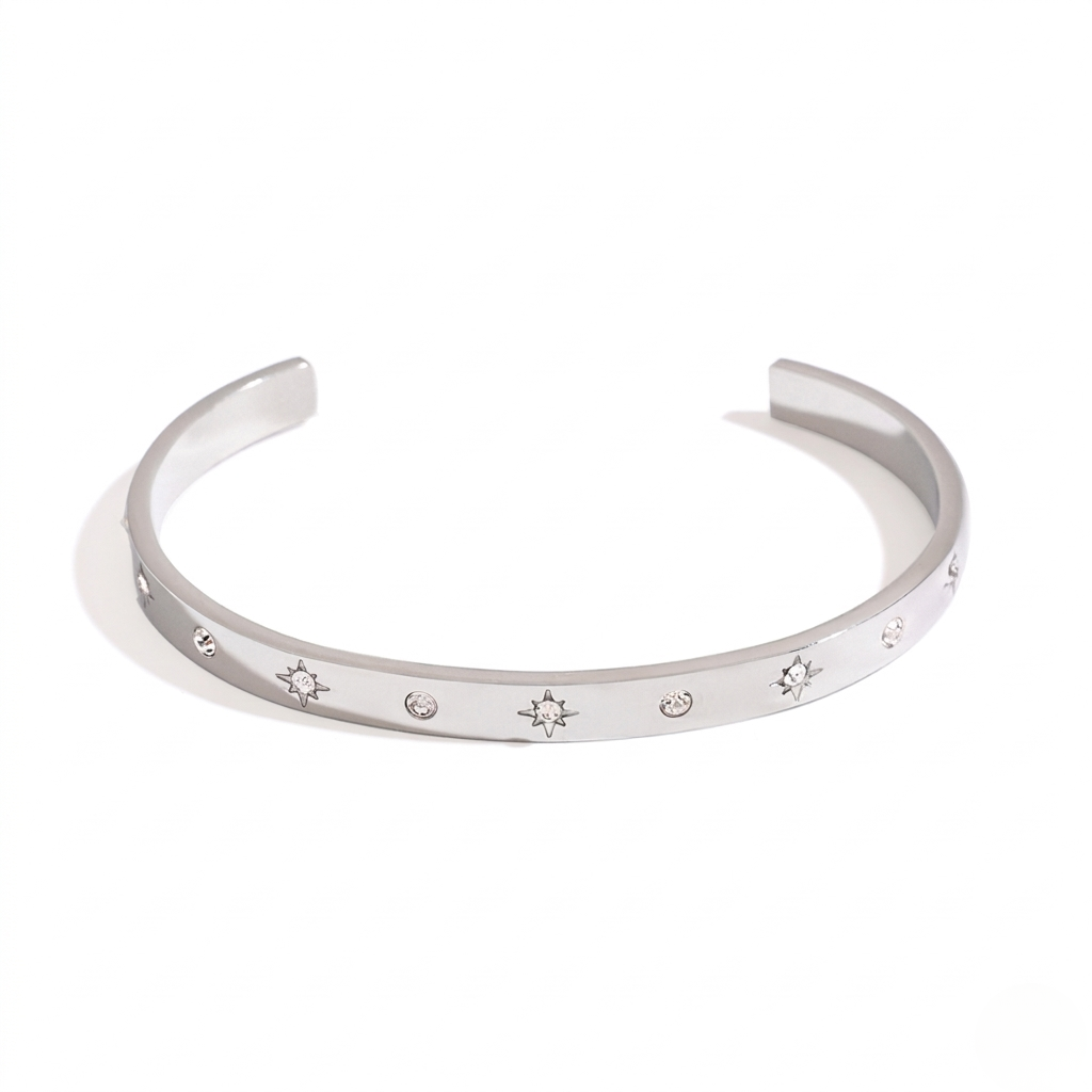 Silver cuff bracelet with starburst engravings and small gemstones