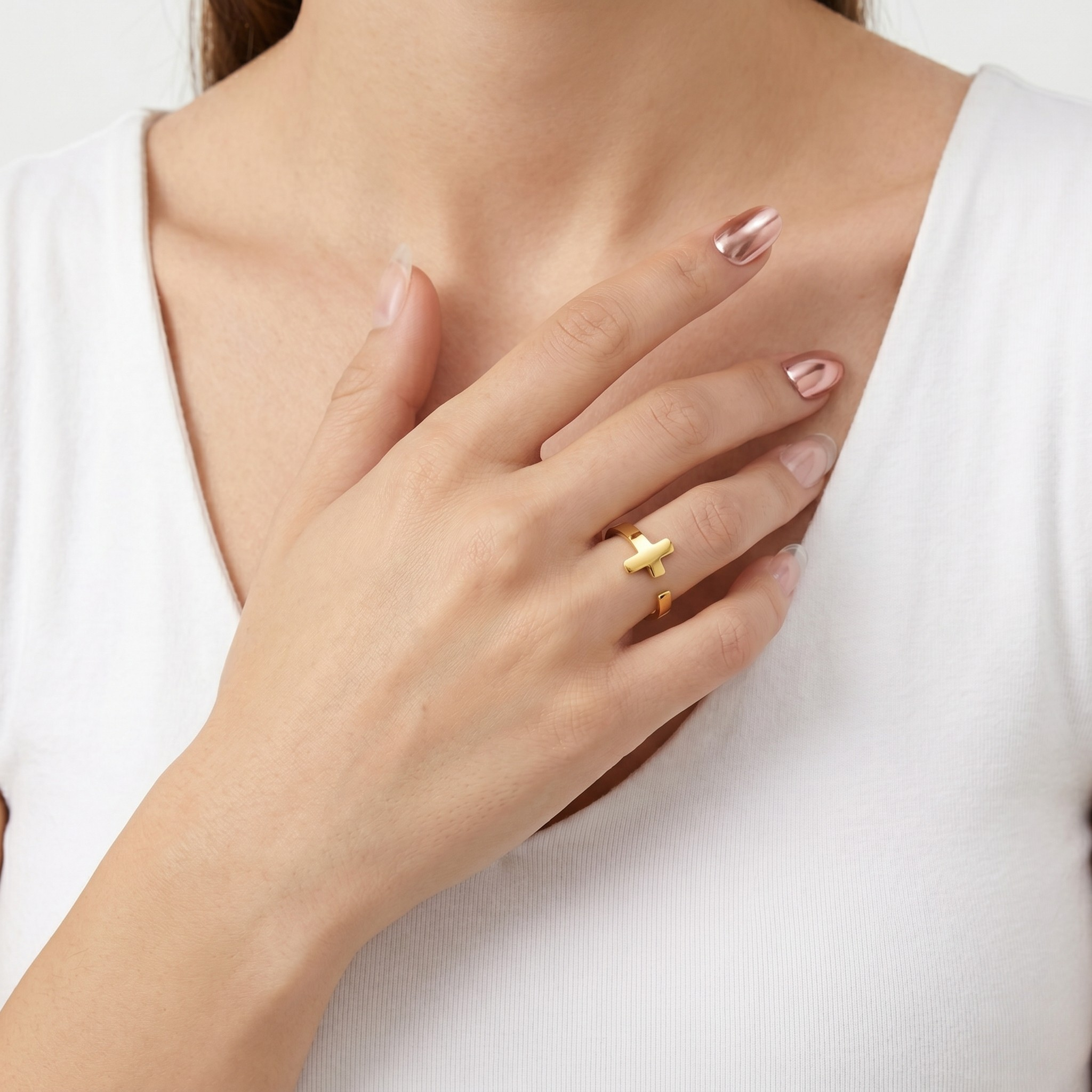 Gold Whisper Ring on model's finger, modern minimal design, worn with white top, hand touching chest
