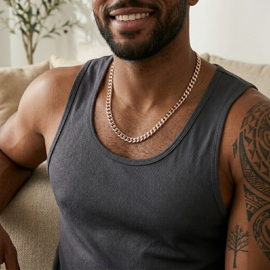 Man wearing Miami Cuban Link Necklace 5mm in gold, sitting on a couch in a casual setting