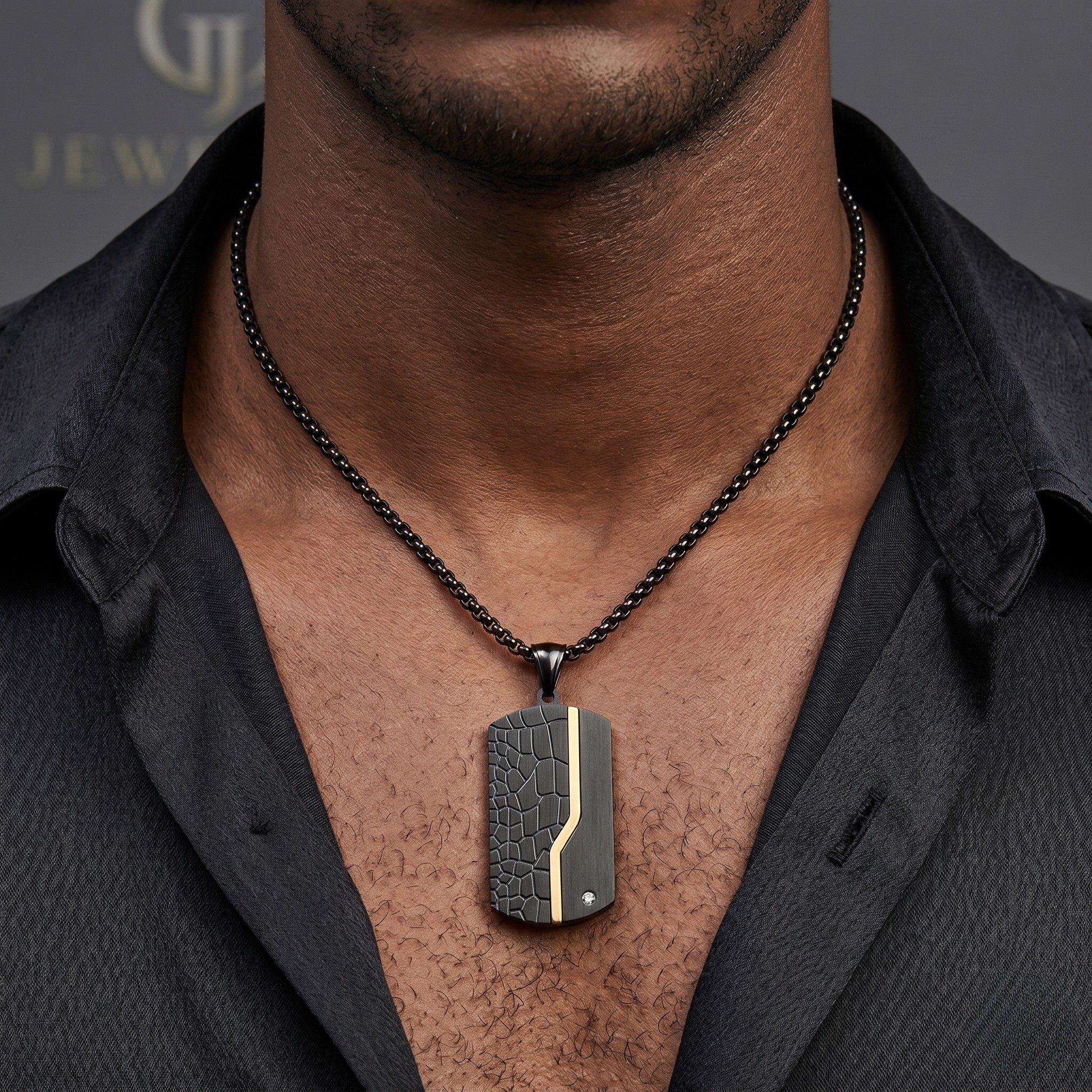 Man wearing black and gold textured pendant necklace with croc pattern and diamond accent on black box chain over open dark shirt - Apex Tag (Black) - J. Collins Jewelry 