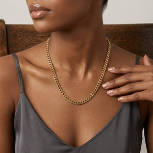 Model Tiffany wearing a classic gold curb link chain necklace paired with a satin gray camisole top | J.Collins Jewelry