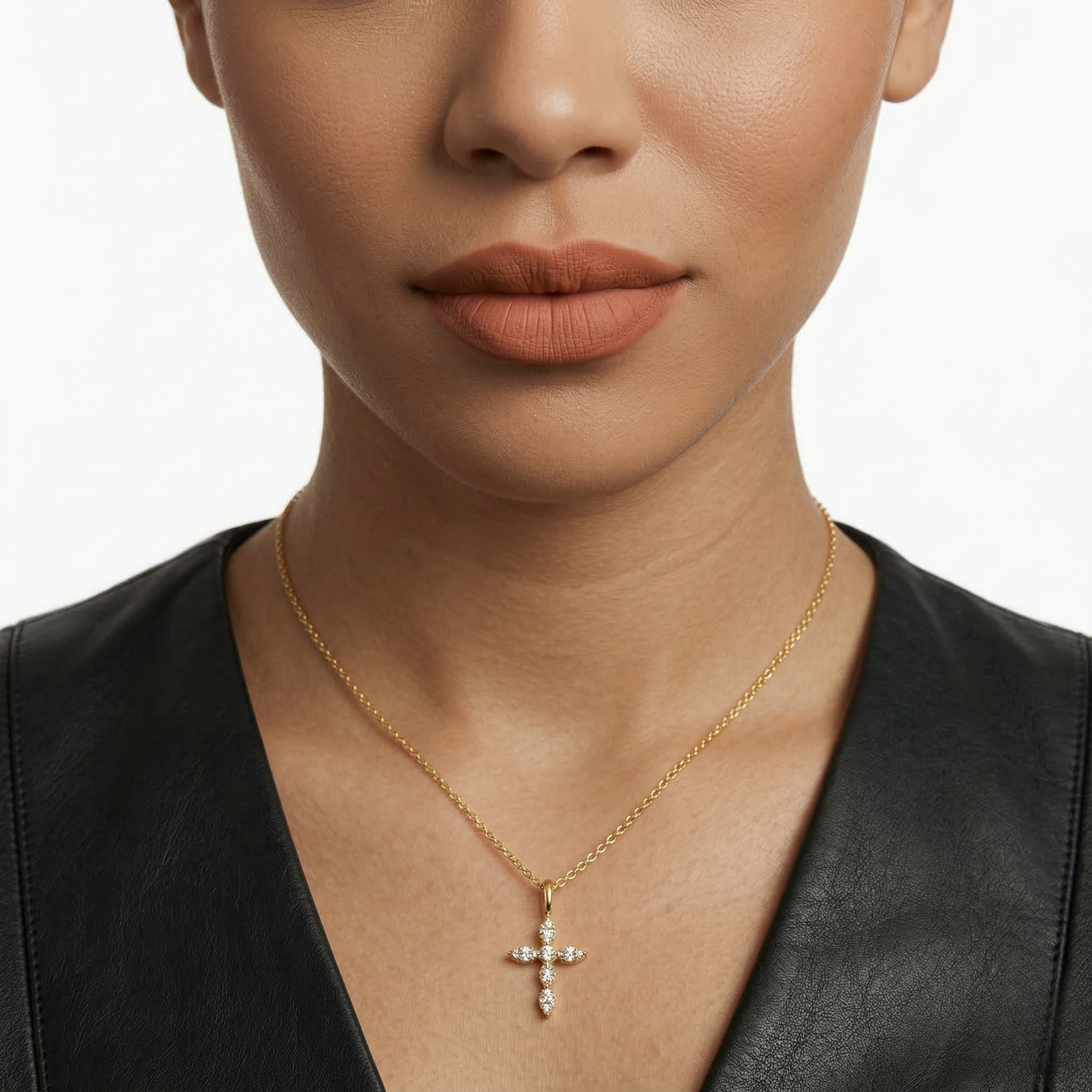 Close-up of a person wearing a gold necklace with a cross pendant on a plain background-J.Collins Jewelry