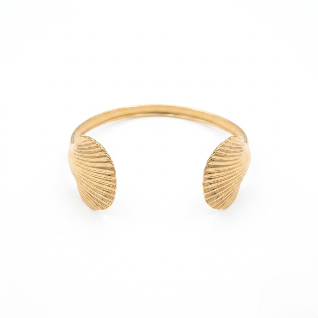Gold bracelet with shell-like designs on a white background. J.Collins Jewelry 