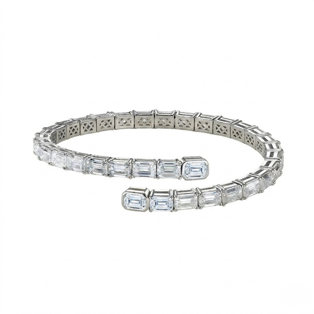 Flexible sterling silver open wrap tennis bracelet handset with emerald-cut cubic Moissanite crystals shown on a plain white background by J.Collins
