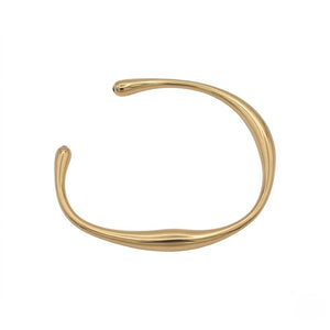 Minimalist chunky gold open cuff bracelet with a fluid, organic wave design isolated on a white background | J.Collins Jewelry