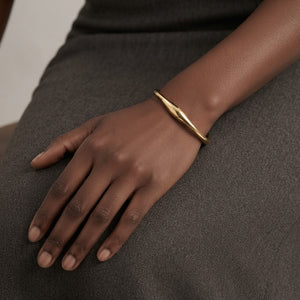 Model wearing a sleek, modern gold open cuff bracelet styled on the wrist | J.Collins Jewelry
