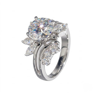 Sterling silver ring featuring a round center cubic Moissanite stone flanked by marquise accents shown at an angle on a plain white background by J.Collins
