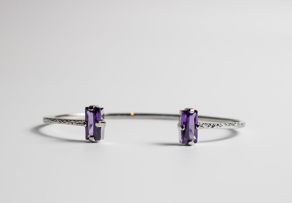 Silver bracelet with purple gemstones on a light gray background - Duara Cuff Bracelet - JCollins Jewelry  