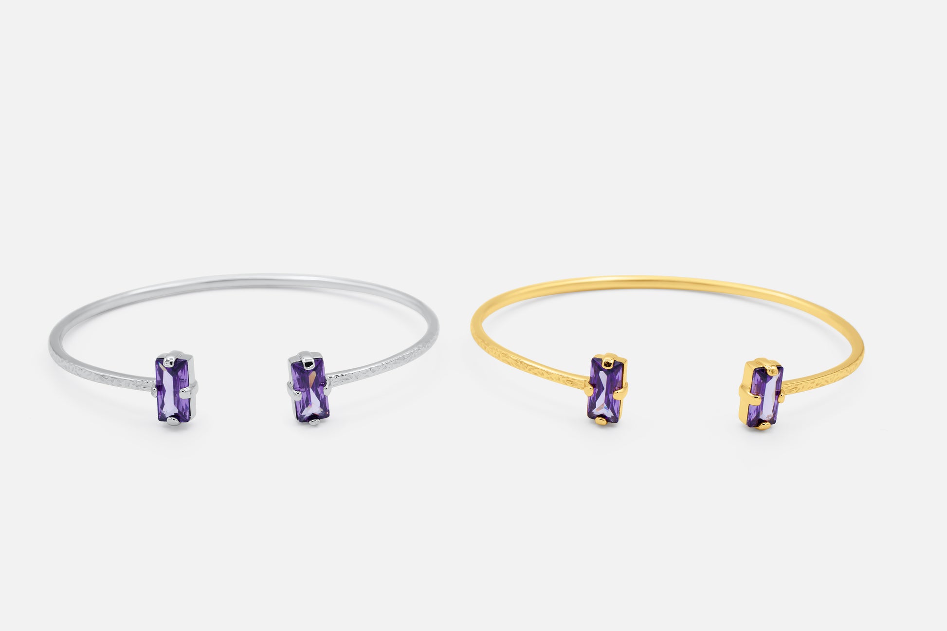 Two bangle bracelets, one silver and one gold, each with a purple gemstone on a white background  - Duara Cuff Bracelet  - JCollins Jewelry  