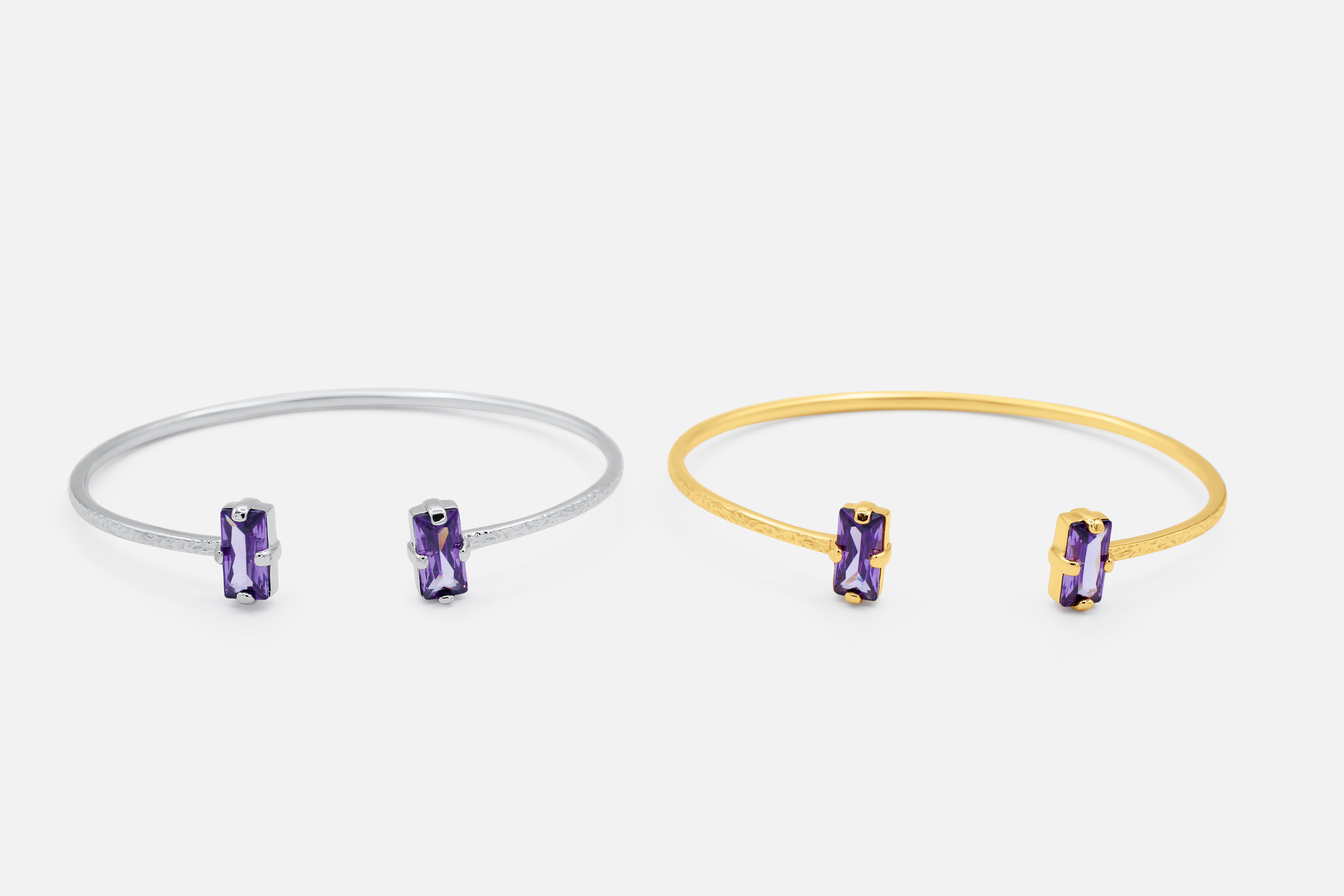 Two bangle bracelets, one silver and one gold, each with a purple gemstone on a white background - Duara Cuff Bracelet - JCollins Jewelry  
