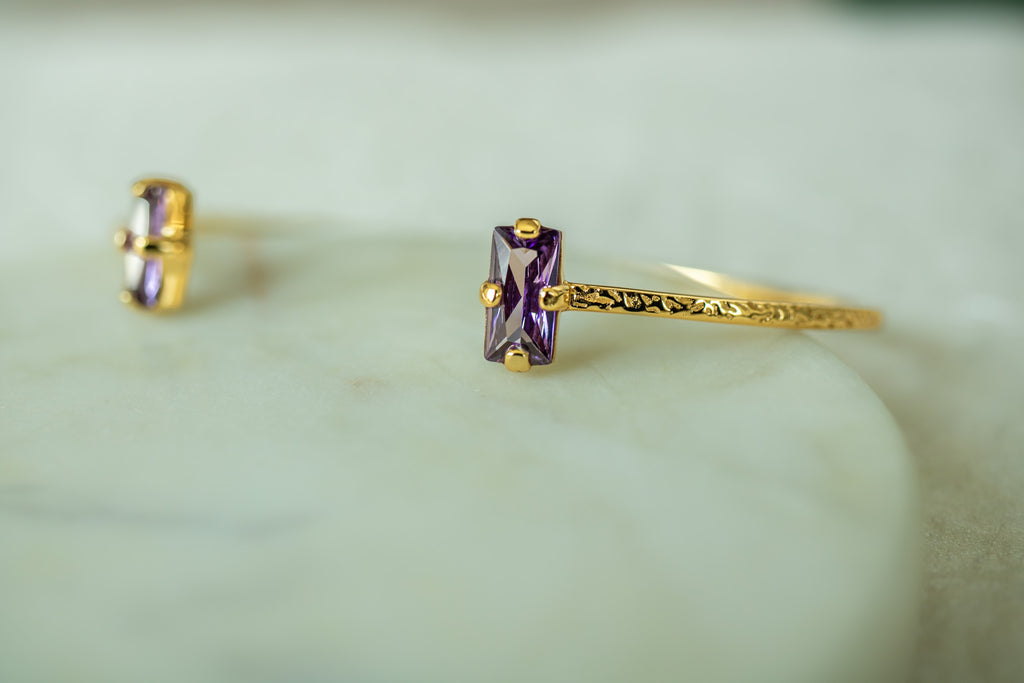 Gold ring with purple gemstone on a light green background  - Duara Cuff Bracelet - JCollins Jewelry  