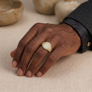 ⁠Gold encrusted pavé dome signet ring styled on hand with dark suit cuff by J.Collins