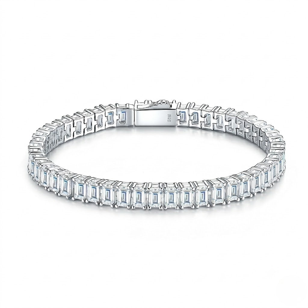 Classic single-row sterling silver tennis bracelet set with emerald-cut cubic Moissanite crystals and a secure box clasp shown on a plain white background by J.Collins
