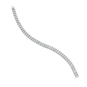 Classic single-row sterling silver tennis bracelet set with emerald-cut cubic Moissanite crystals unclasped in an S-curve layout on a plain white background by J.Collins
