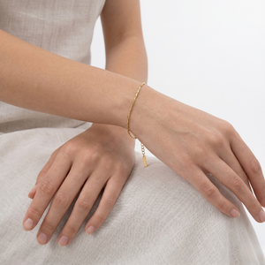 Gold bracelet on a person's wrist with a neutral background-J.Collins Jewelry