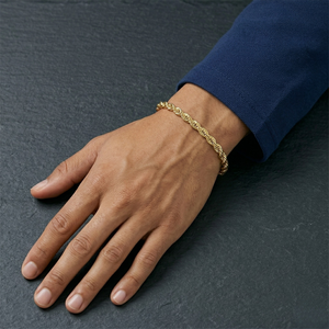 Hand wearing a gold rope bracelet on a dark surface- Essential Rope Bracelet 5mm (Gold ) by J.Collins Jewelry 