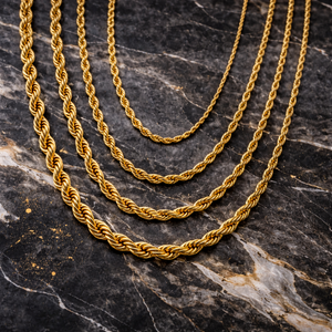Multiple gold rope chain necklaces in varying widths displayed on dark marble surface - Essential Gold Chain - J. Collins Jewelry 