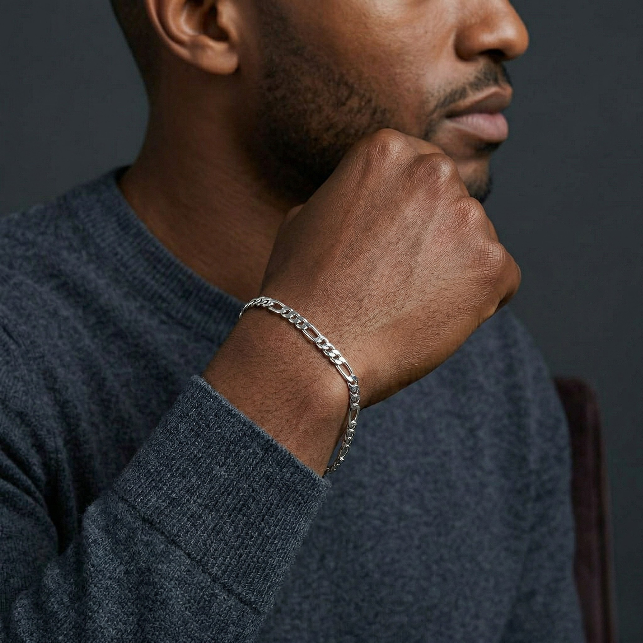 Man wearing a silver bracelet on his wrist against a dark background-J.Collins Jewelry