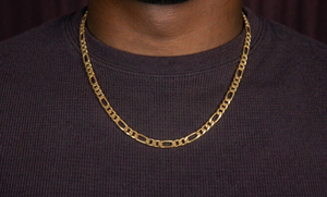 Gold chain necklace on a person wearing a dark shirt on a black background- J.Collins Jewelry