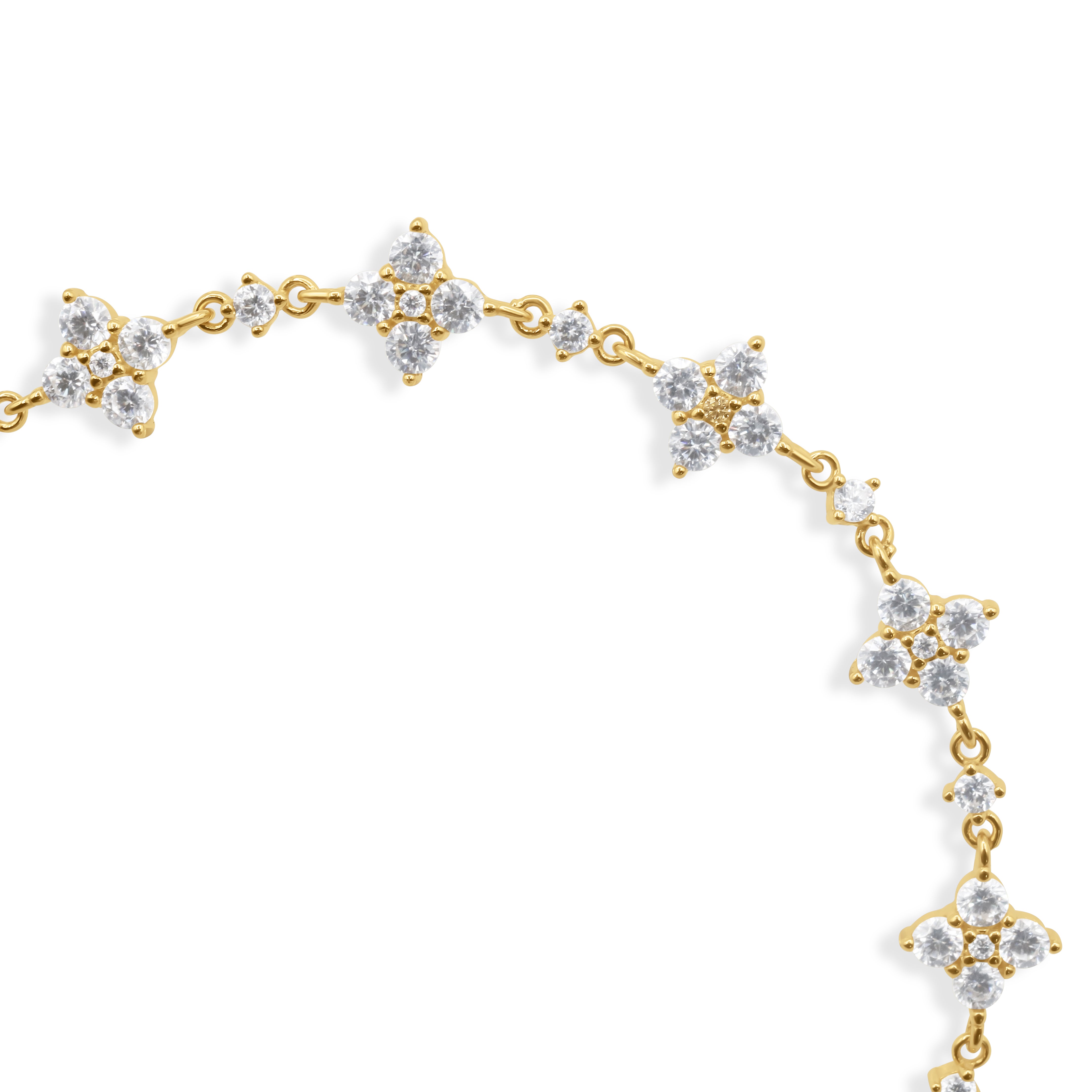 Gold bracelet with diamond-like stones on a white background
