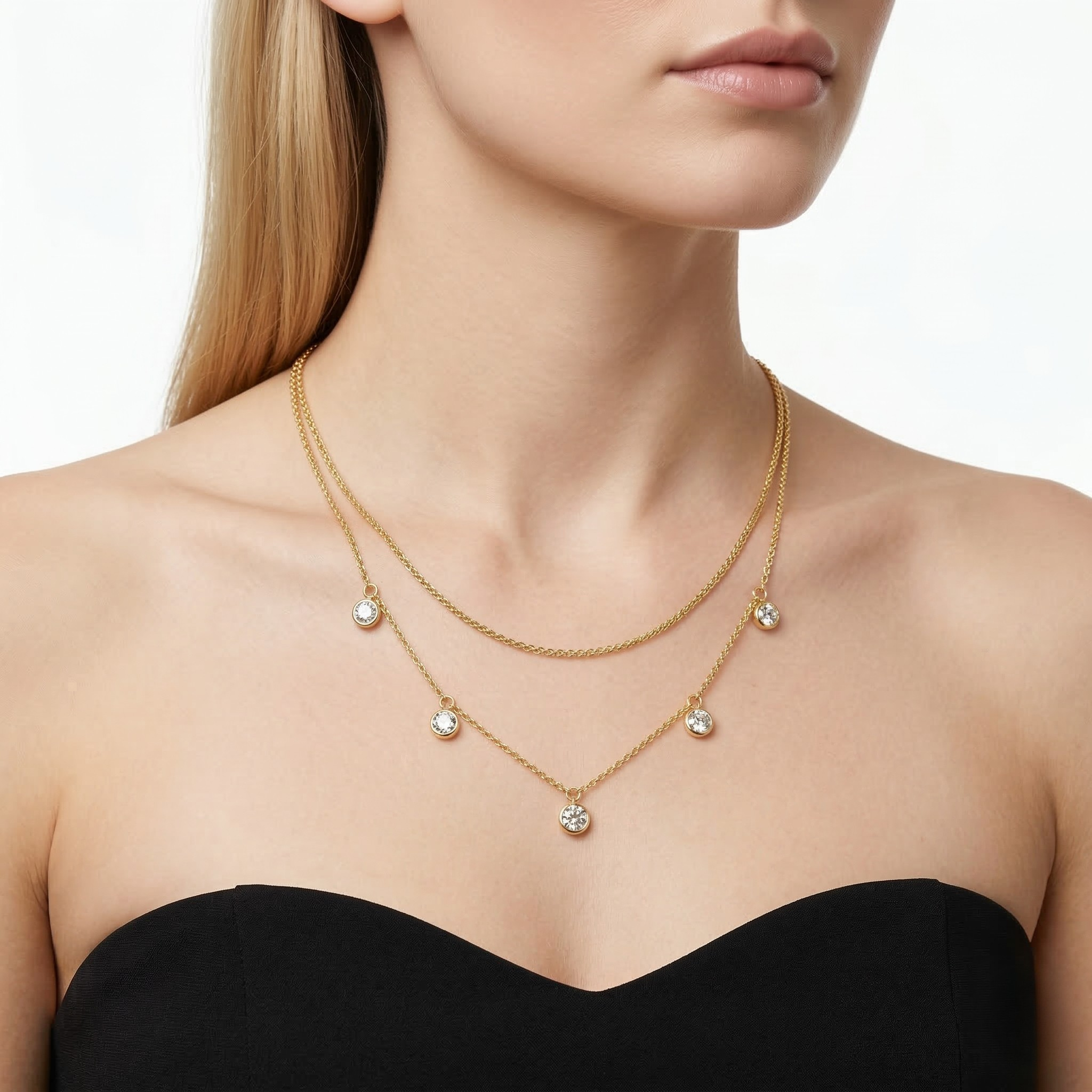 Woman wearing a gold necklace with small pendants on a plain background- J.Collins Jewelry 