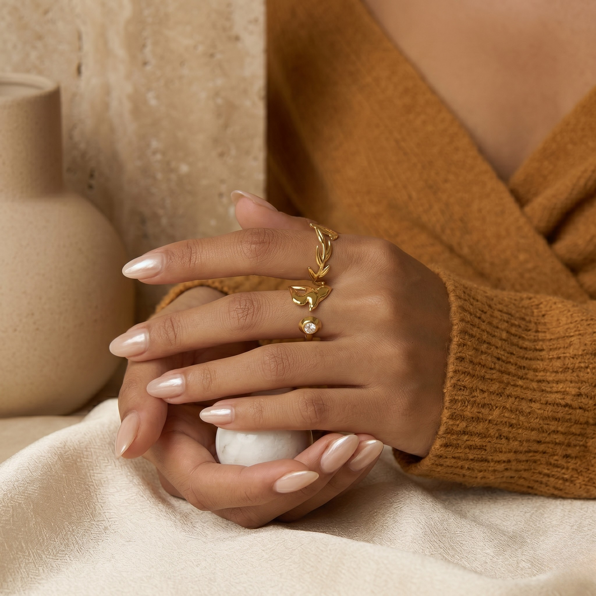 Foliage-inspired gold ring worn on hand, showcasing elegant curves in a serene, neutral setting - J.Collins Jewelry