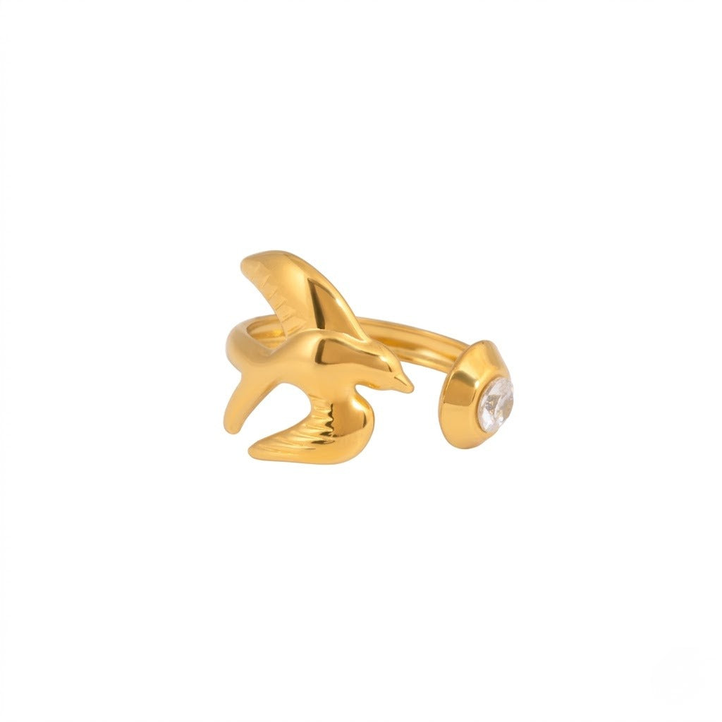 A gold-plated bird-shaped ring with a small clear crystal on the side, shown against a plain white background - J.Collins Jewelry