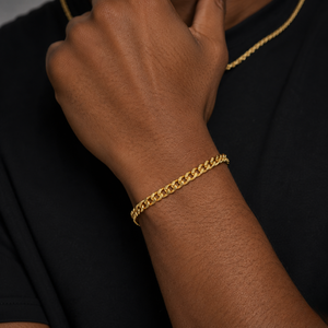 Gold chain bracelet on a wrist around the chin, dark background black shirt - JCollins-Jewelry