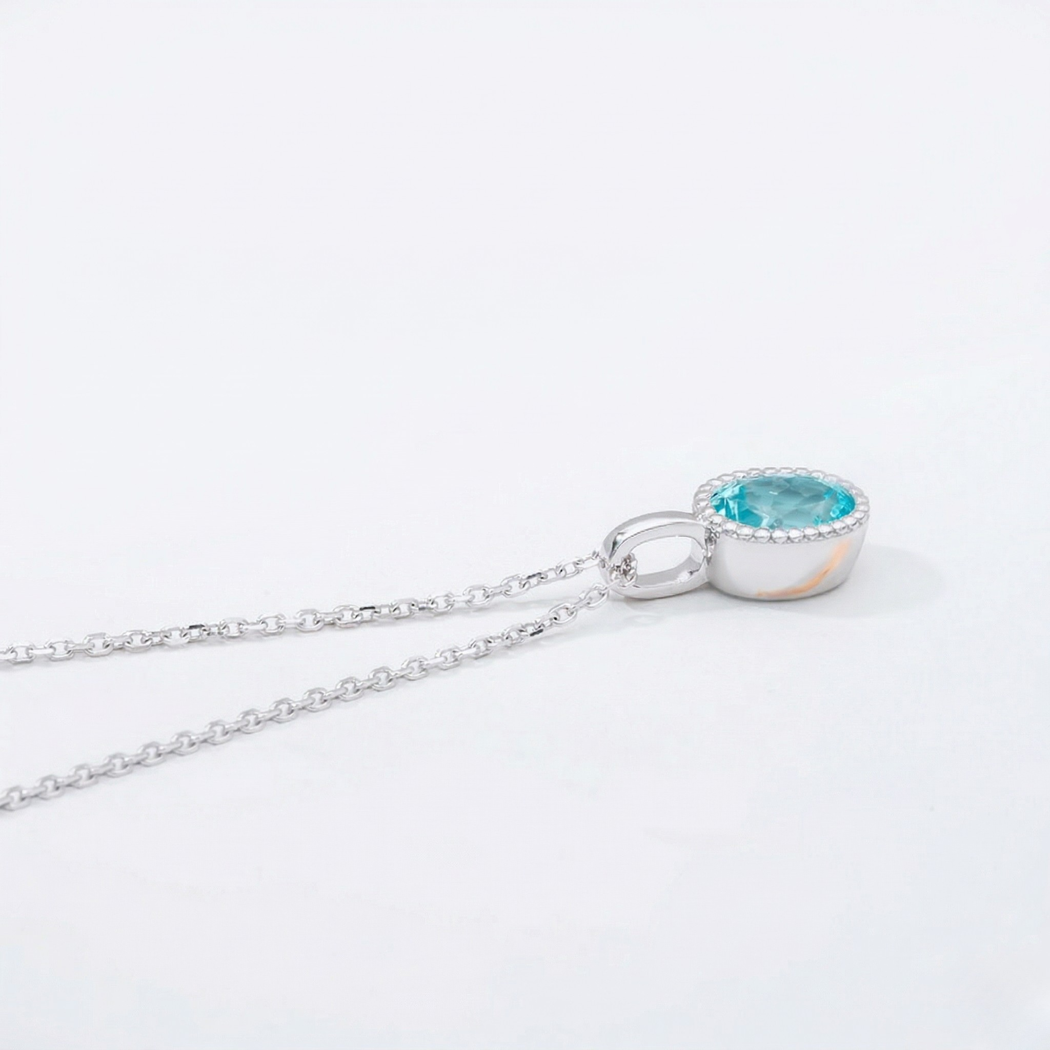 Silver necklace with a blue gemstone pendant on a white background J. Collins Jewelry 