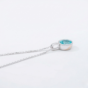 Silver necklace with a blue gemstone pendant on a white background J. Collins Jewelry 