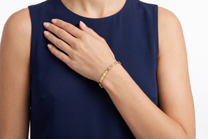 Woman wearing a gold bracelet on a navy-blue sleeveless top- J.Collins Jewelry