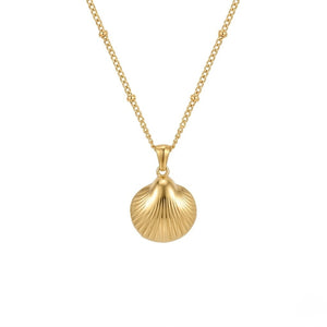 Polished gold scallop shell pendant necklace on a beaded chain shot against white | J.Collins Jewelry
   