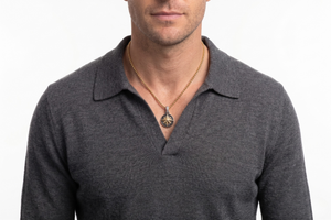 Man wearing a gray polo shirt with a Gold Medallion on a white background- J.ollins Jewelry