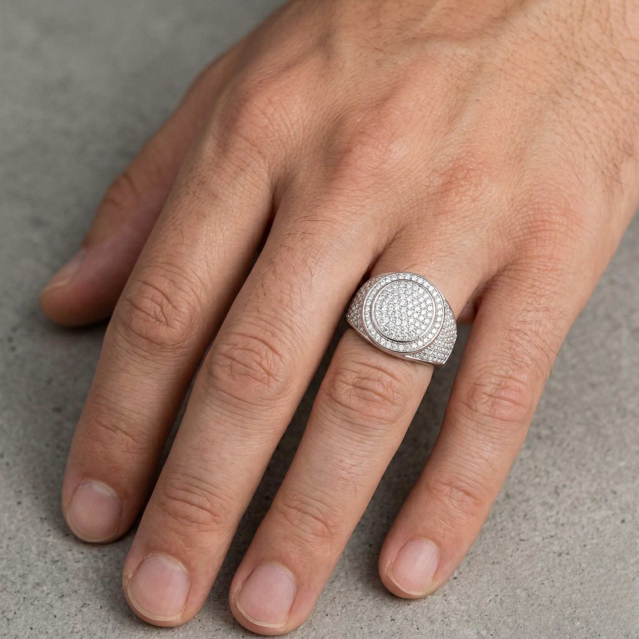 Hand wearing white gold fully iced out pavé diamond oval signet ring - Iced-Out_White_Gold_Ring - J. Collins 