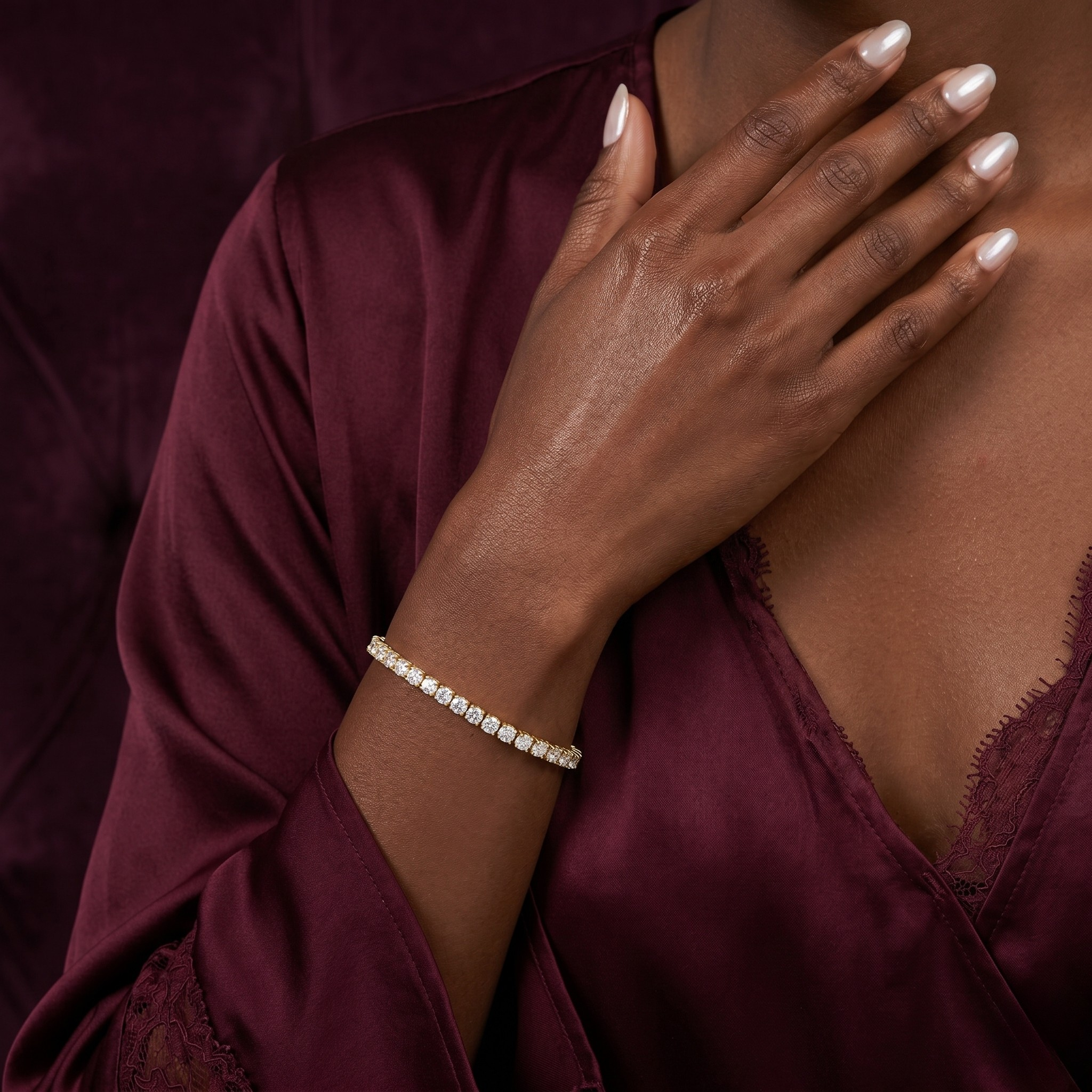 Close-up of a hand wearing a bracelet on a maroon fabric background - Icon Tennis Link Bracelet - J. Collins Jewelry 