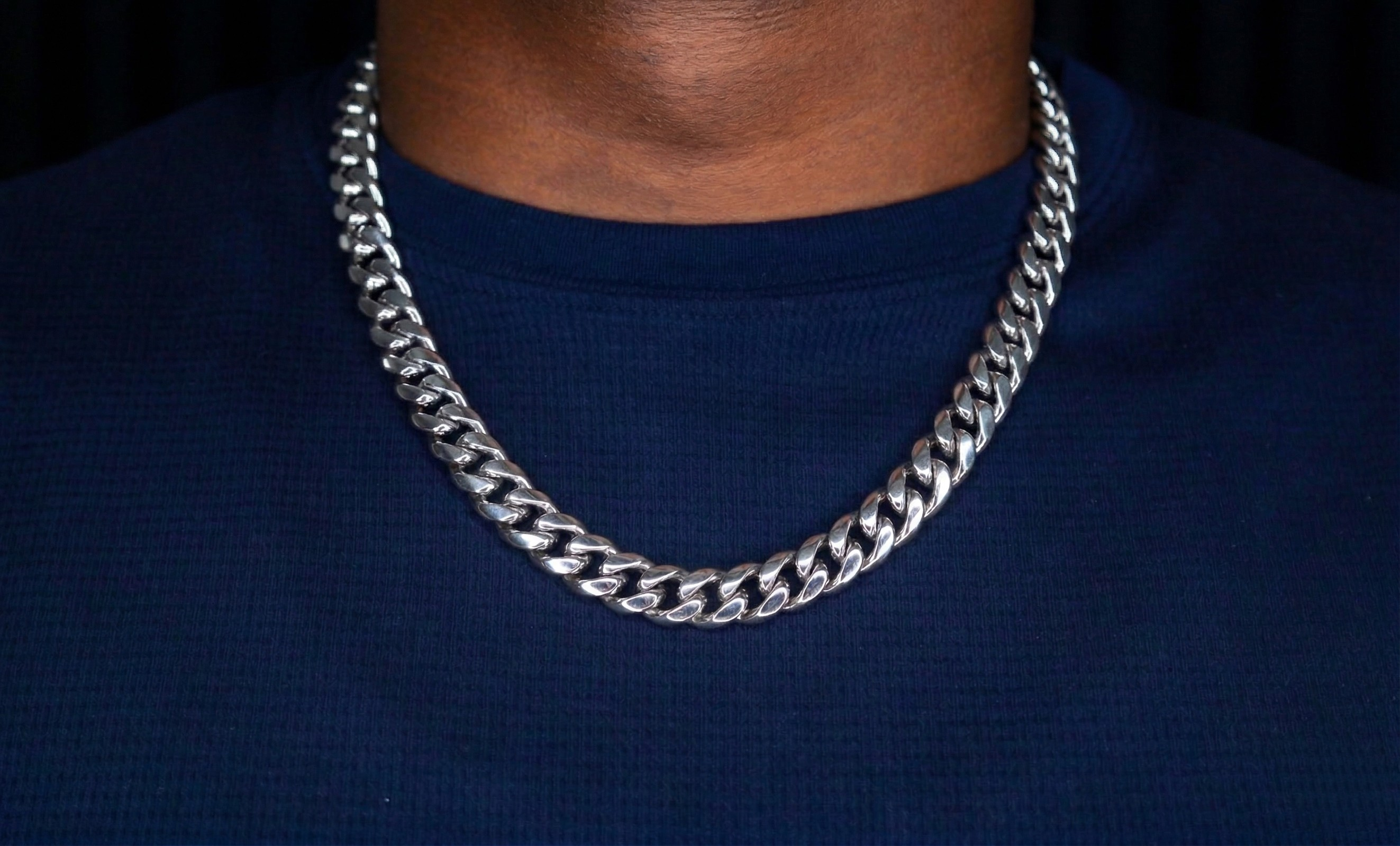 Silver chain necklace on a person wearing a dark blue shirt-Iconic-Cuban-Chain-JCollins-Jewelry