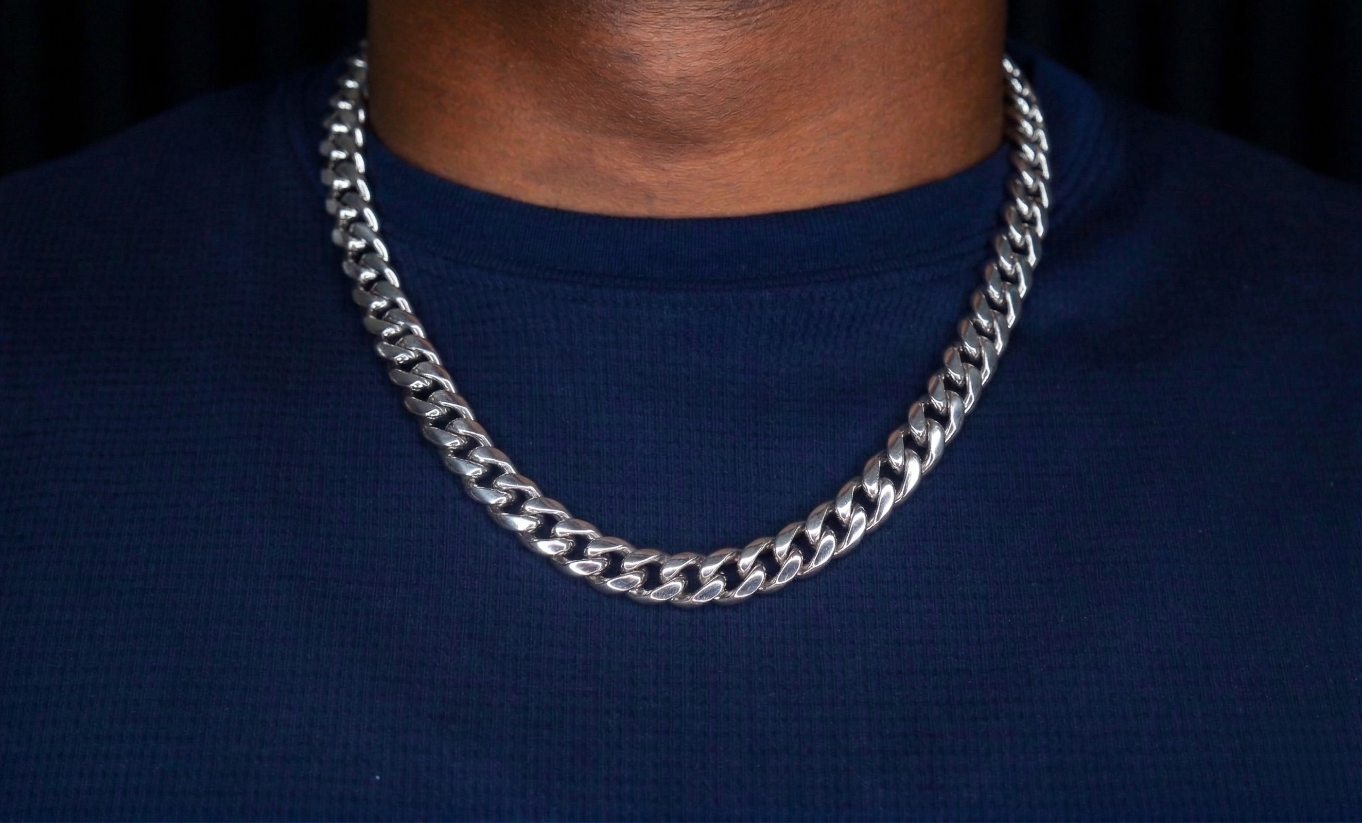 Silver chain necklace on a person wearing a dark blue shirt-Iconic-Cuban-Chain-JCollins-Jewelry
