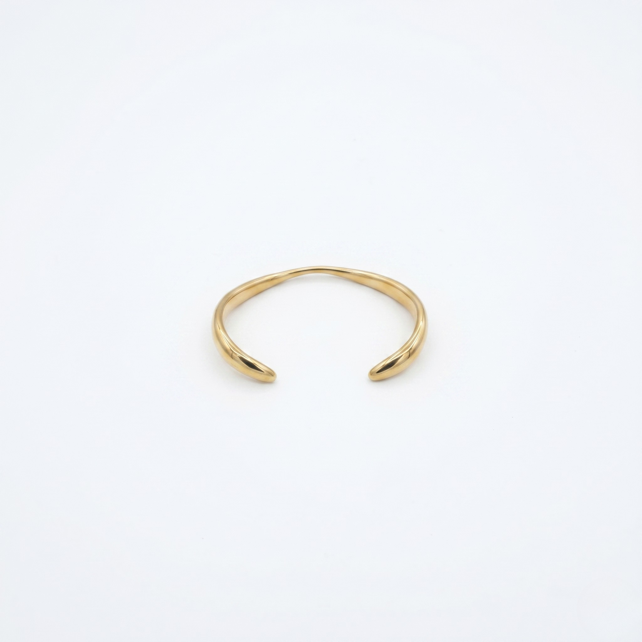 Gold open cuff on a white background- J.Collins Jewelry