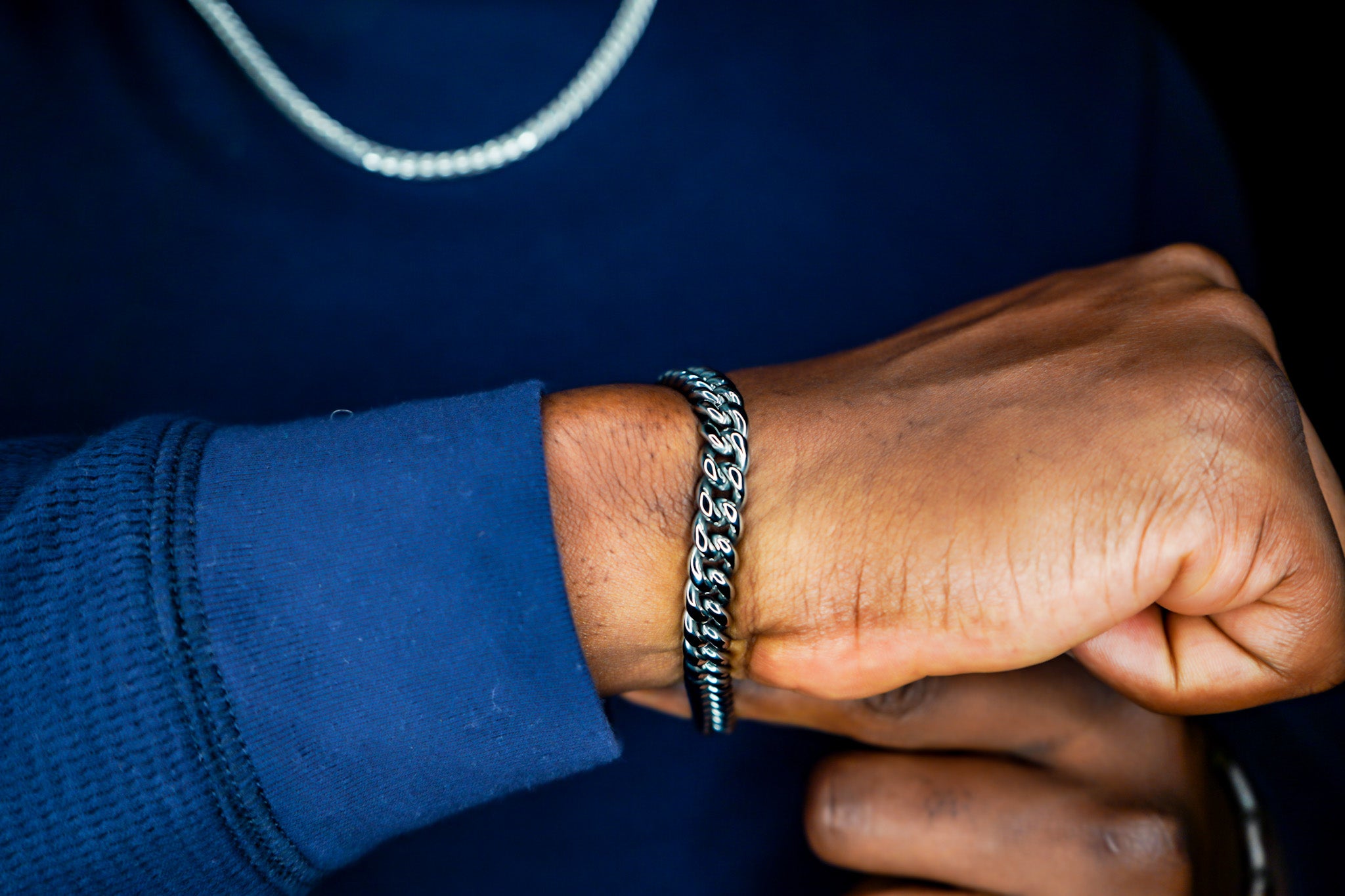Person wearing a silver bracelet on a dark background-Iconic-Cuban-Bracelet-JCollins-Jewelry