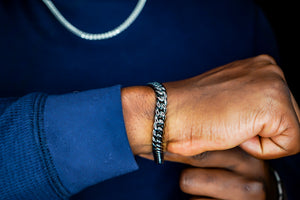 Person wearing a silver bracelet on a dark background-Iconic-Cuban-Bracelet-JCollins-Jewelry