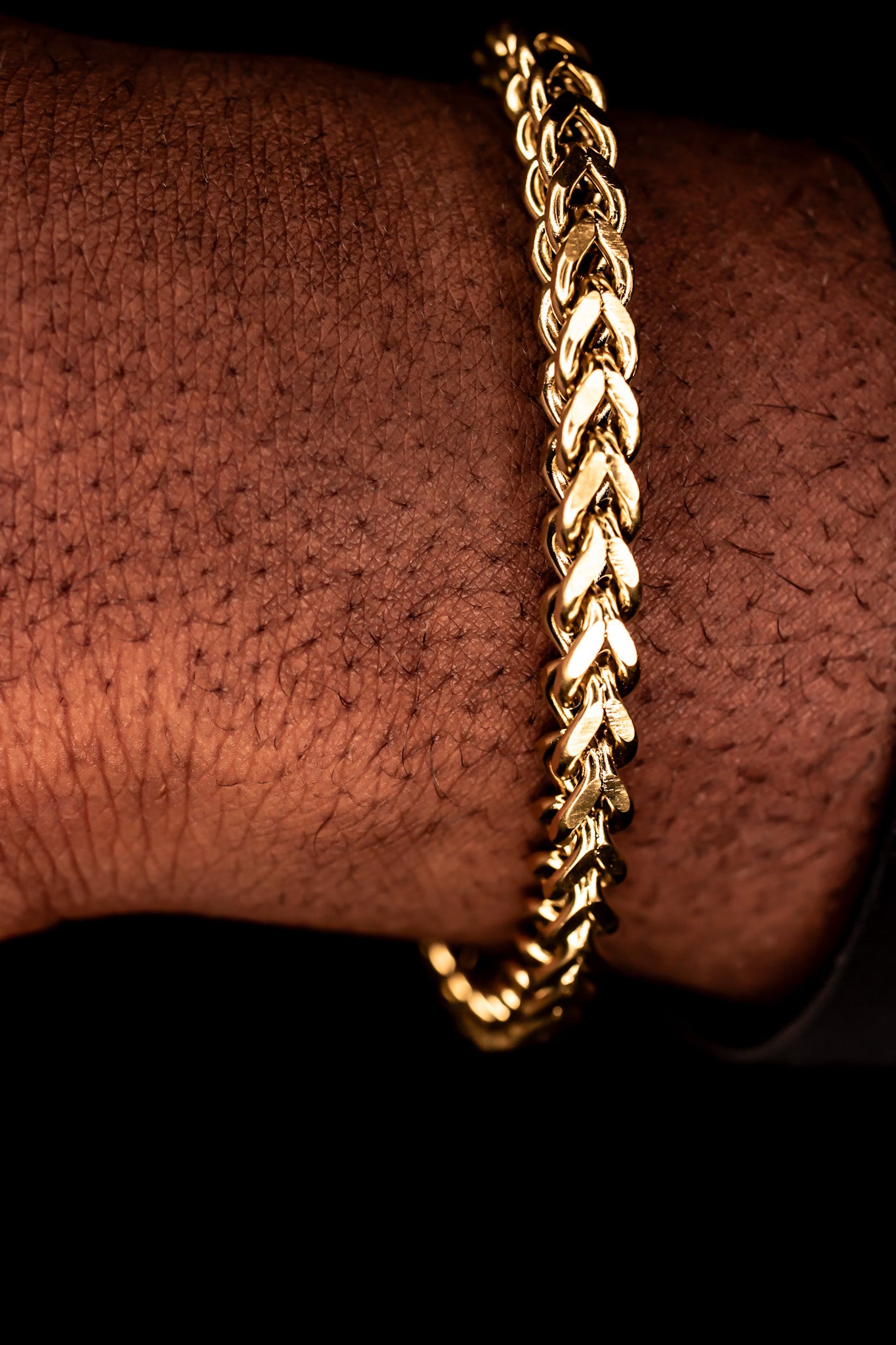 Gold chain bracelet on a wrist against a dark background-Signature-Franco-Bracelet-JCollins-Jewelry