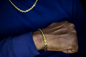 Gold chain bracelet on a wrist with a blue background-Vermeil-Rope-Bracelet-JCollins-Jewelry