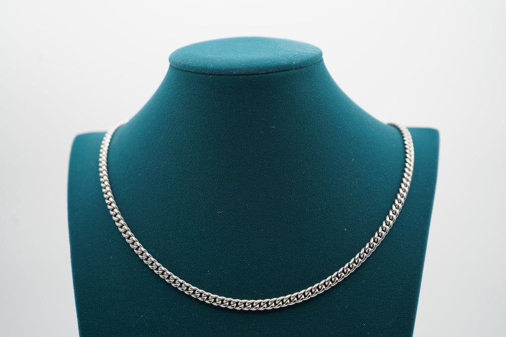 Silver chain necklace on a green mannequin bust against a white background-Iconic-Cuban-Chain-JCollins-Jewelry