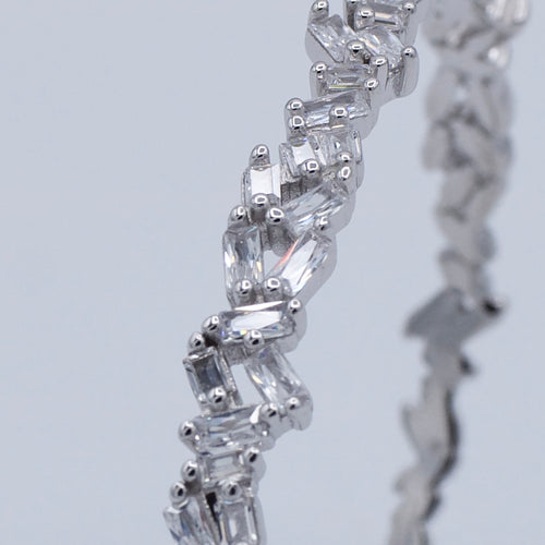 Close-up of a diamond tennis bracelet on a light gray background-Crystal-Eclat-Cuff-JCollins-Jewelry