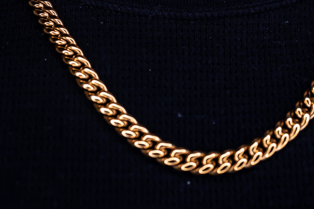 Gold chain necklace on a black background-Iconic-Cuban-Chain-JCollins-Jewelry