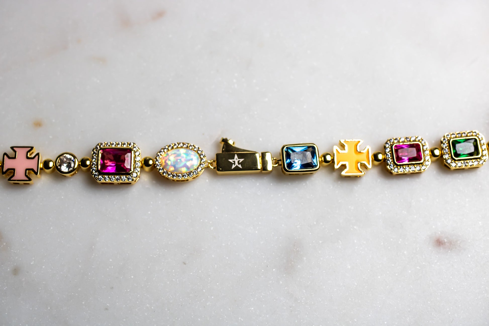 Gold bracelet with colorful gemstones on a light marble - MultiColored-Regal-Gem-Chain-JCollins-Jewelrybackground