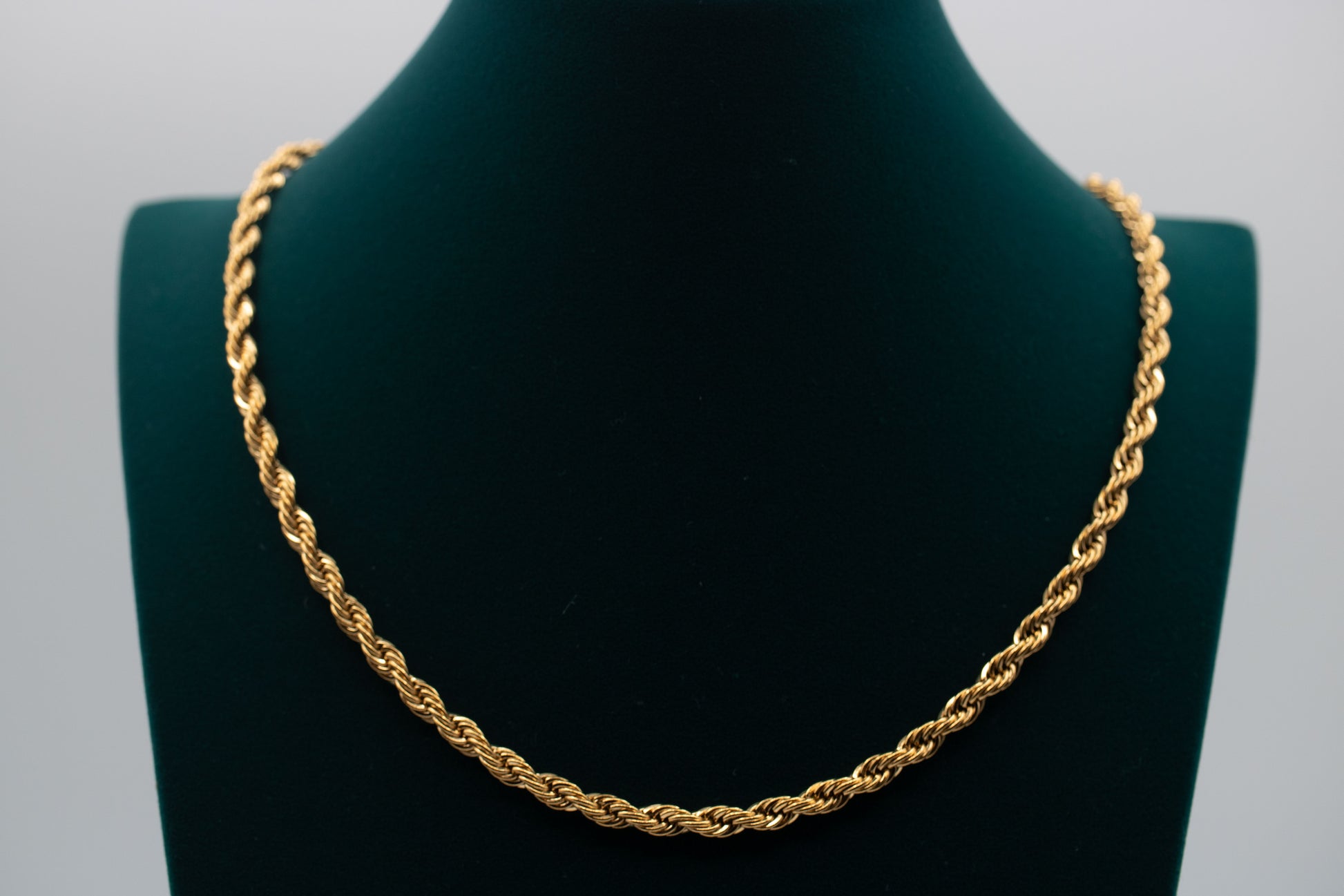 Gold rope chain necklace on a black mannequin bust against a gray background-Essential-Rope-Chain-JCollins-Jewelry
