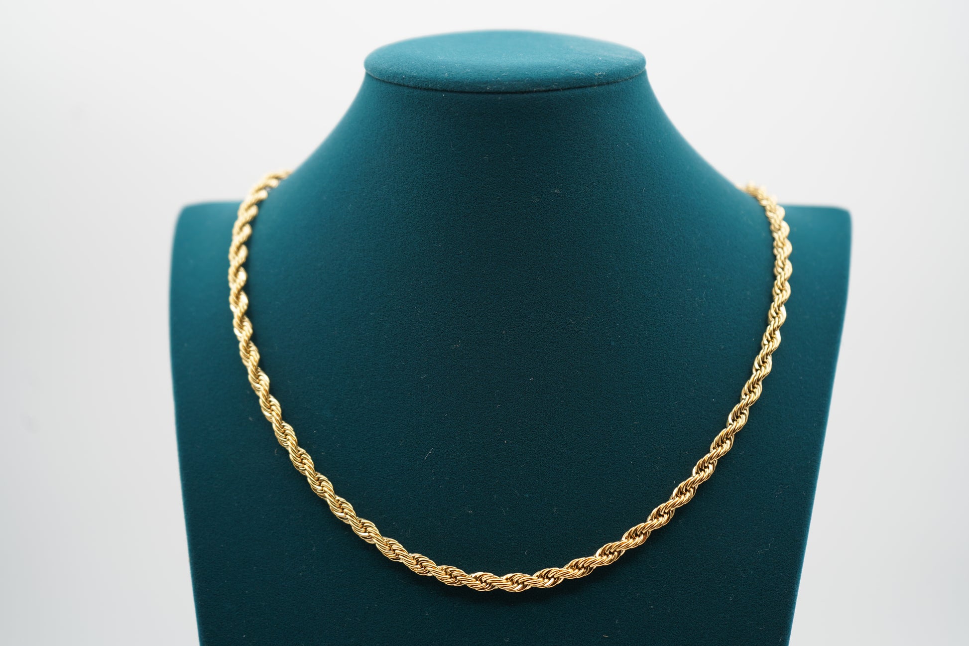 Gold chain necklace on a green mannequin bust against a white background-Essential-Rope-Chain-JCollins-Jewelry