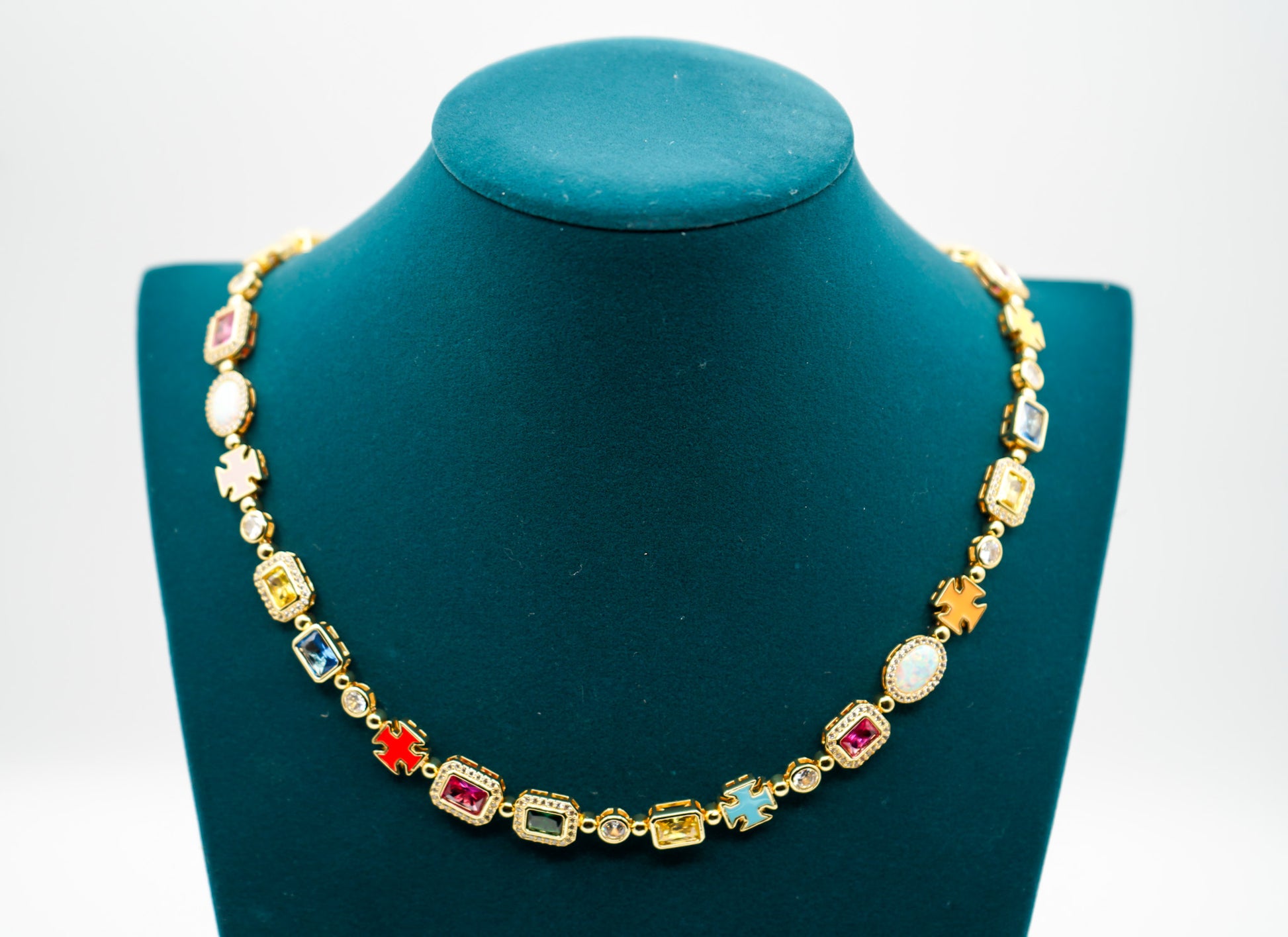 Gold necklace with colorful gemstones on a green mannequin against a white background- MultiColored-Regal-Gem-Chain-JCollins-Jewelry