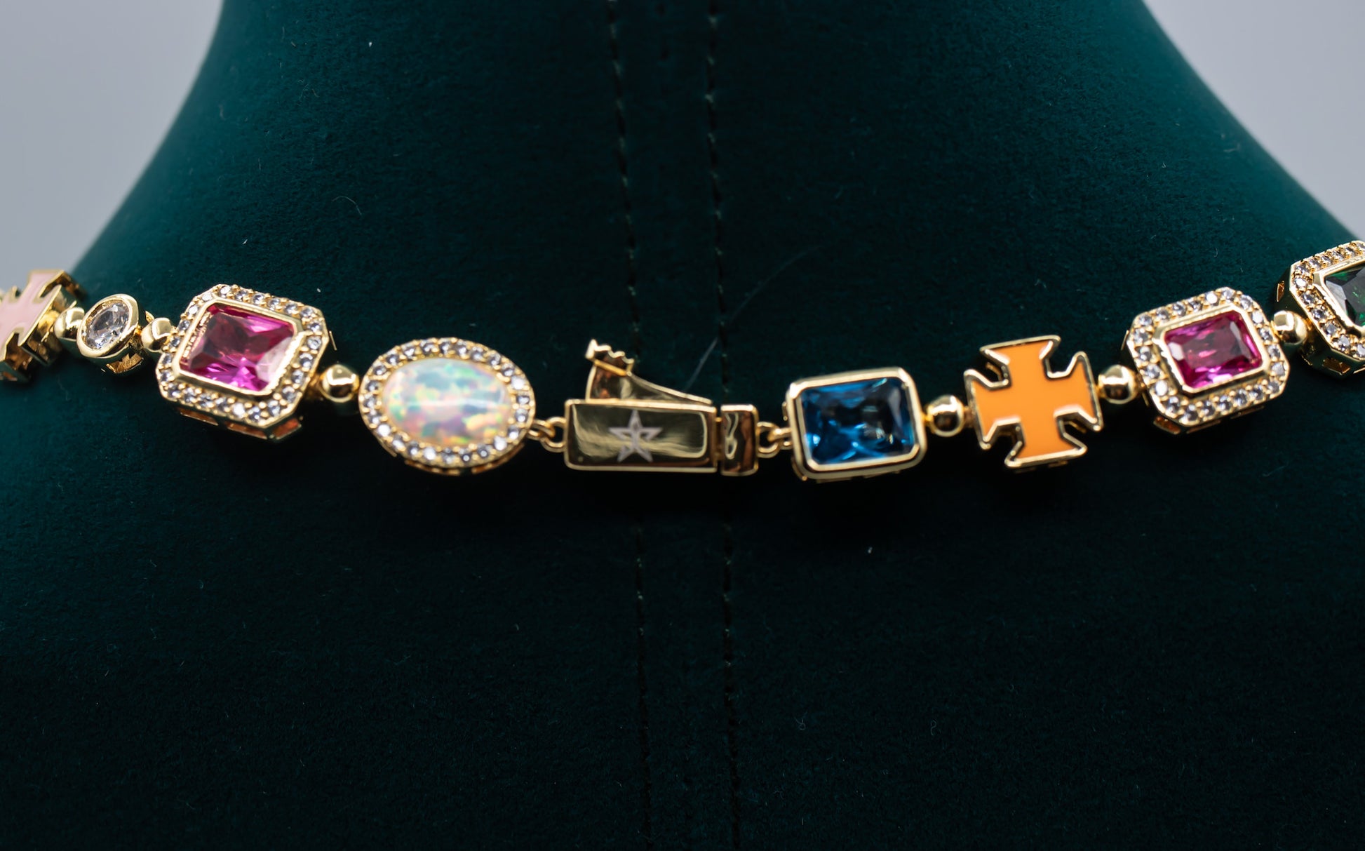 Gold bracelet with colorful gemstones on a black stand- MultiColored-Regal-Gem-Chain-JCollins-Jewelry